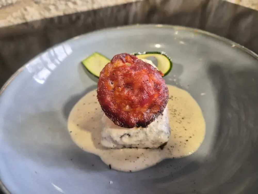 Un plat avec une pièce de viande accompagnée de sauce. restaurant cuisine traditionnelle bistrot du commerce